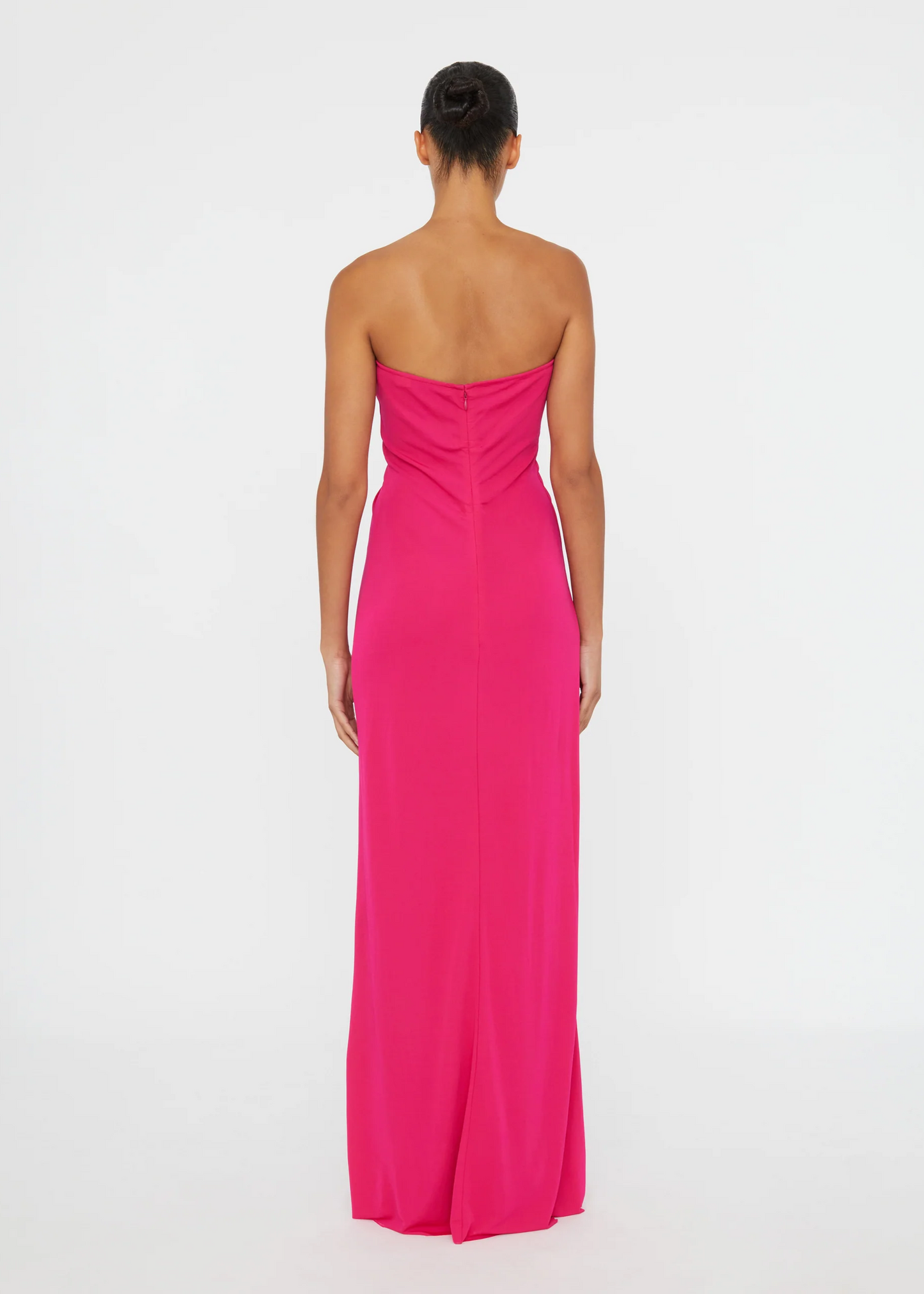 Woman wearing a strapless pink gown on a white background