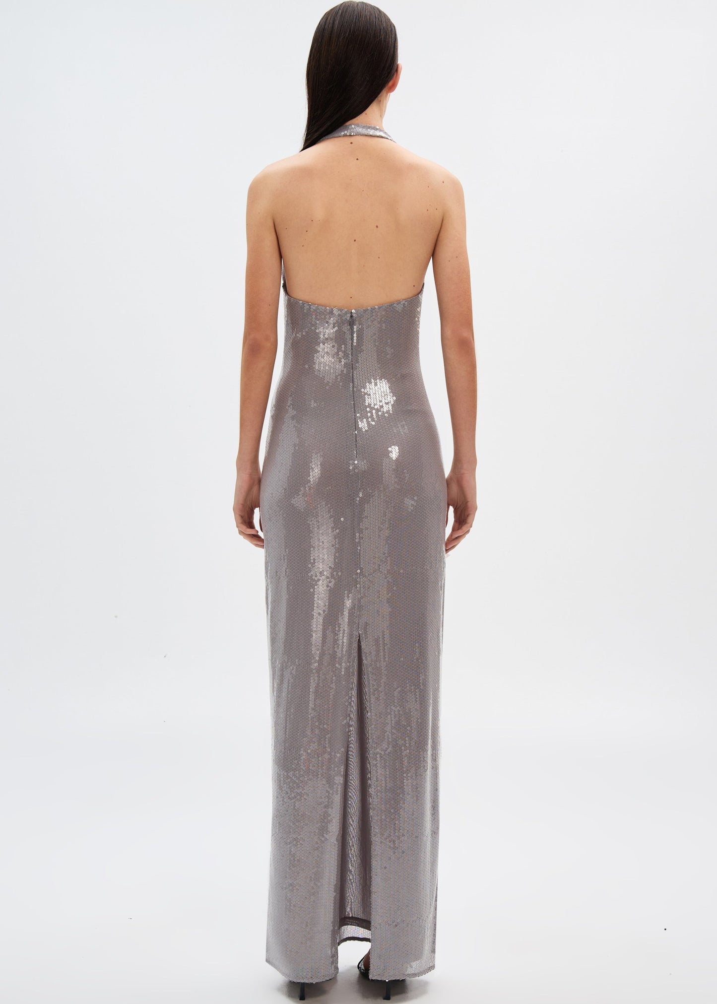 Woman wearing a silver sequin gown on a white background