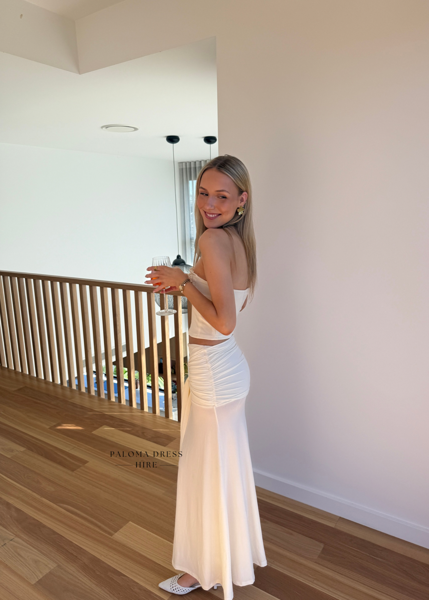 Woman in a white dress standing in a modern interior setting