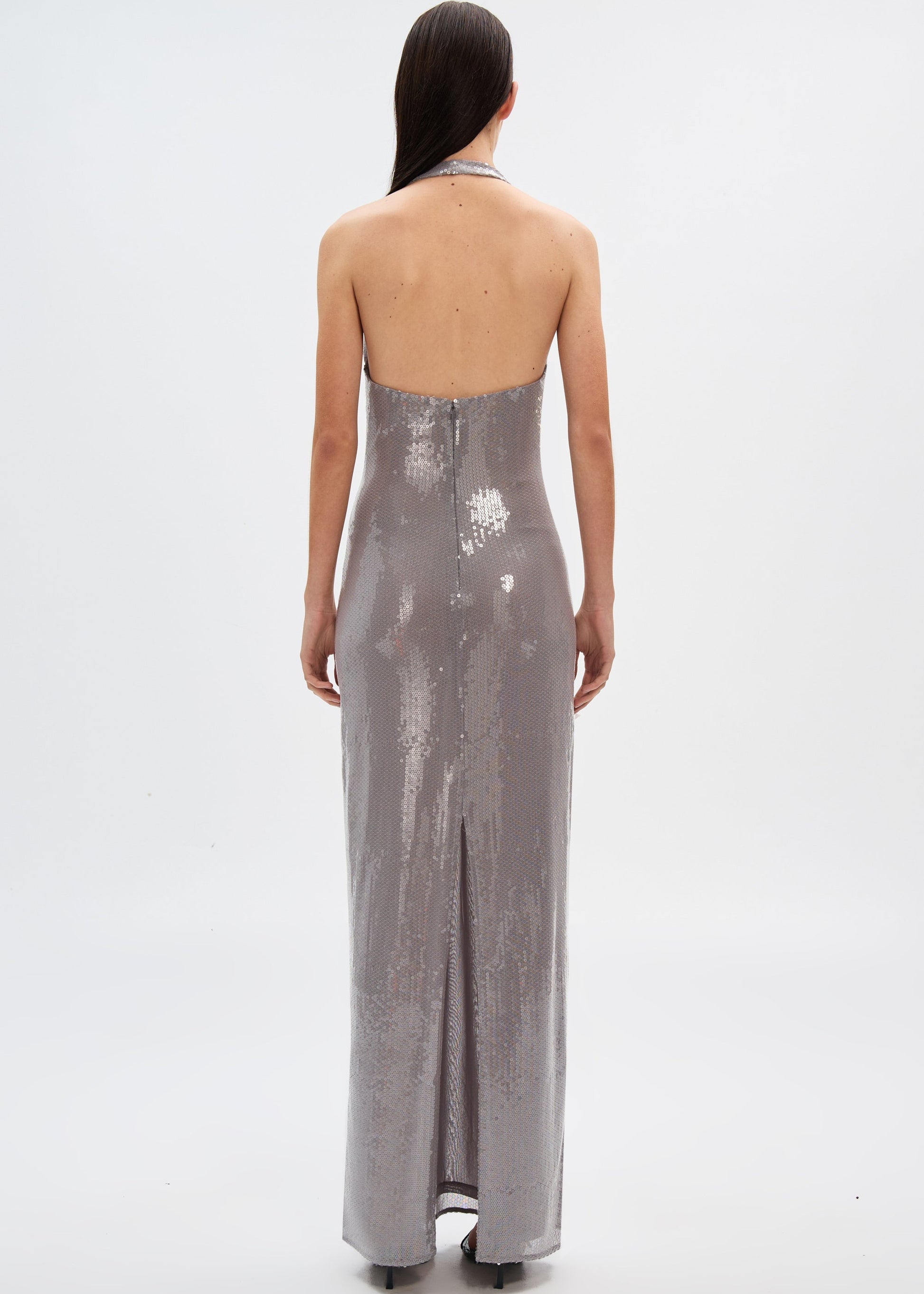 Woman wearing a silver sequin gown on a white background
