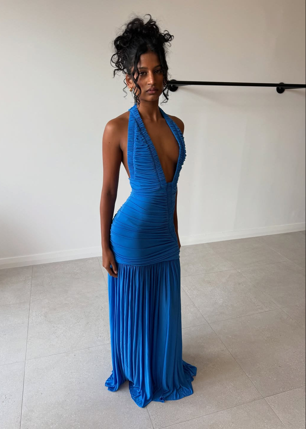 Woman wearing a blue dress in a minimal indoor setting